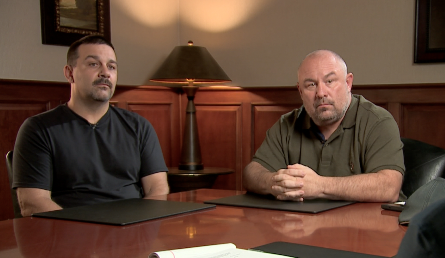 Police lights reflected in a car mirror at night.